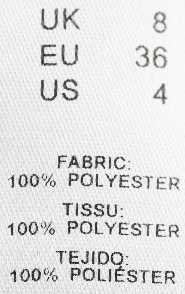 Etiqueta de nylon color blanco donde se específica material y talla para ropa, Fabricante: Etimex Digital en Mexico.
